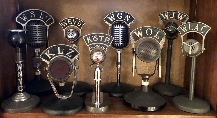 Collection of vintage radio station studio microphones. Stations include WLAC Nashville, WJW Cleveland, WOL Washington, DC, WGN Chicago, WNYC & WEVD New York City